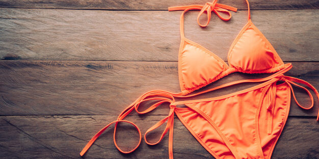 orange-bikini-rests-wooden-floor-summer-travel-cocept_11304-1159